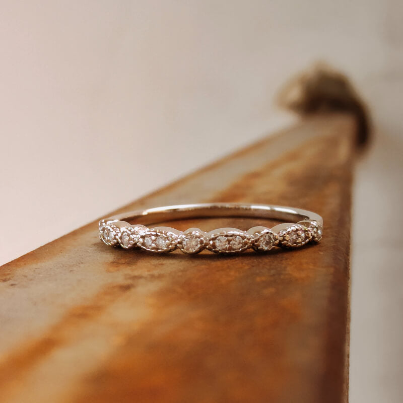 Sterling silver vintage diamond band ring on rustic wooden surface
