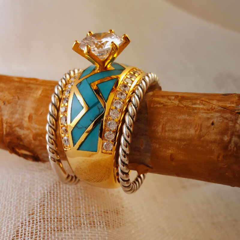 Gold turquoise twist band ring with diamond accents on wooden surface