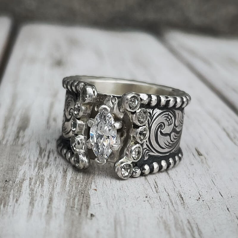 Wide band silver engagement ring with marquise diamond and floral engravings
