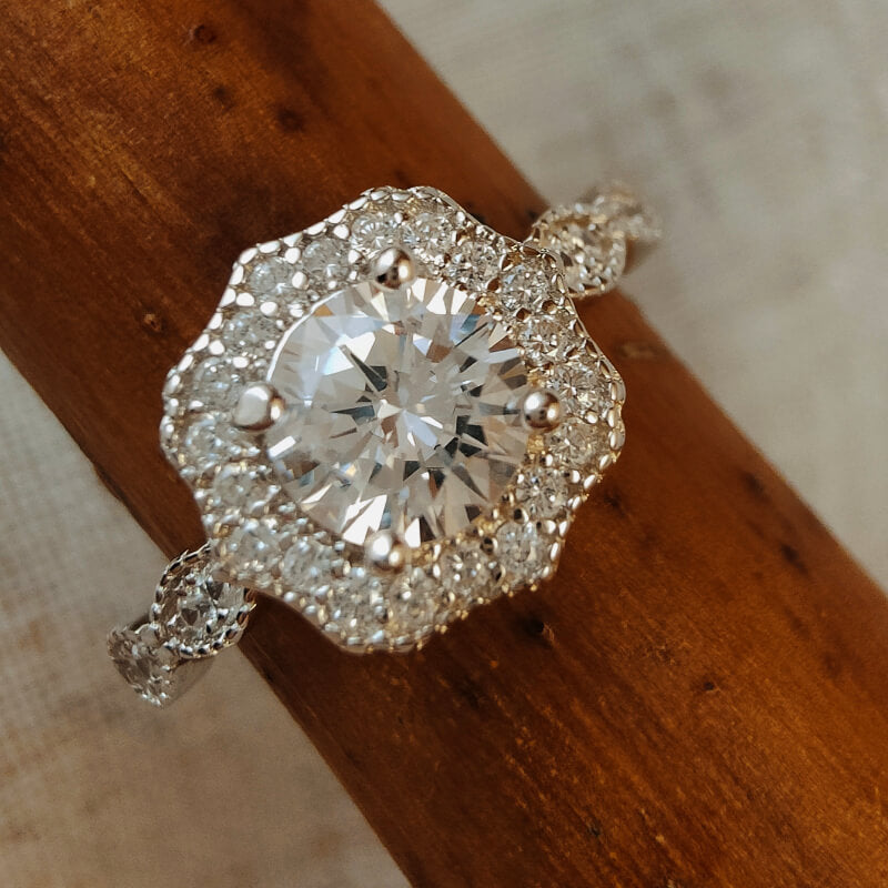 Sterling silver vintage moissanite engagement ring with ornate design.