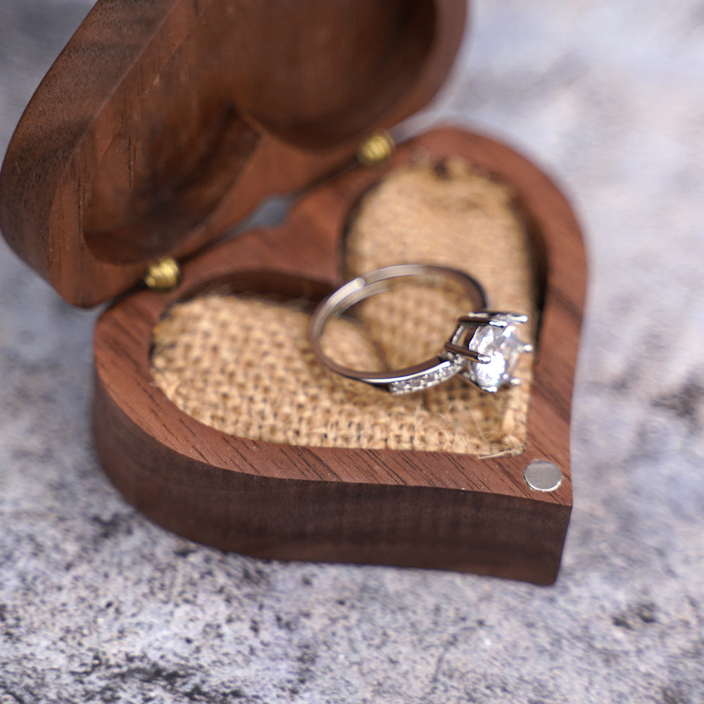 Heart-shaped walnut box with diamond engagement ring inside.