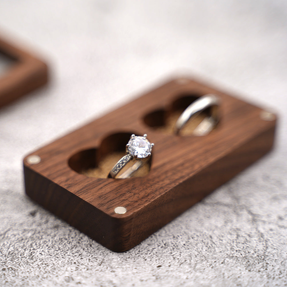 Dark walnut heart gift box with two rings, including a gemstone ring.