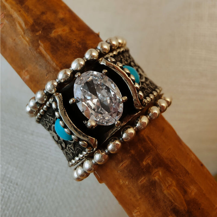 Sterling silver ring with oval zircon and turquoise accents, detailed design.