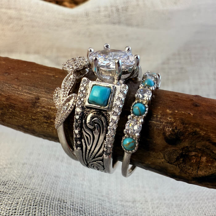 Three stacked vintage rings with turquoise stones and sparkling diamond details