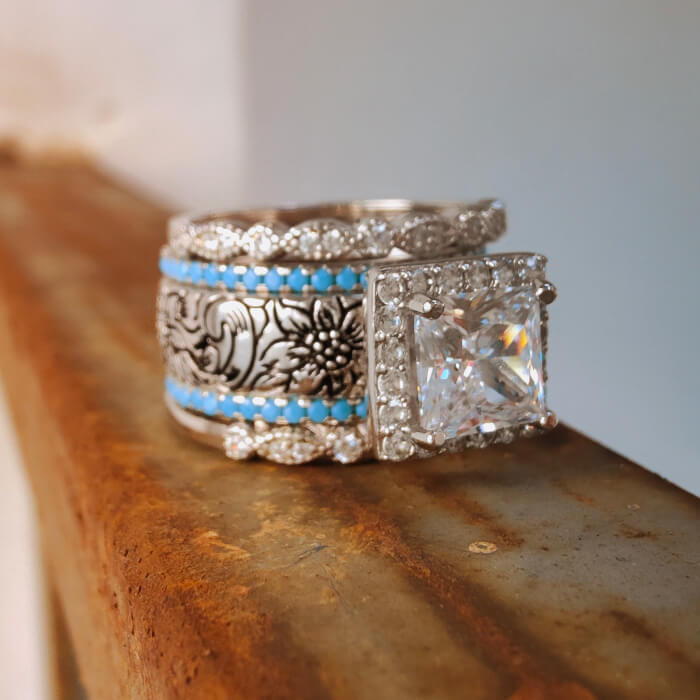 Engagement ring with princess cut zircon, turquoise accents, and floral engraved band.
