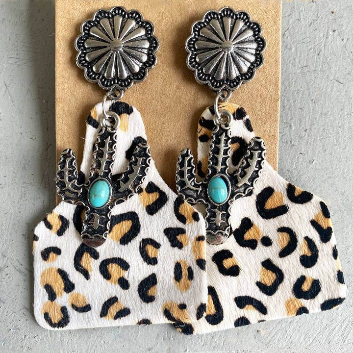 Turquoise cactus earrings with silver tops on leopard print backing.