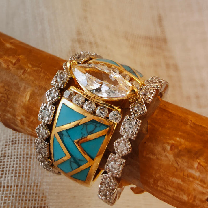 3-piece sterling silver ring set with turquoise and diamond accents stacked on wood