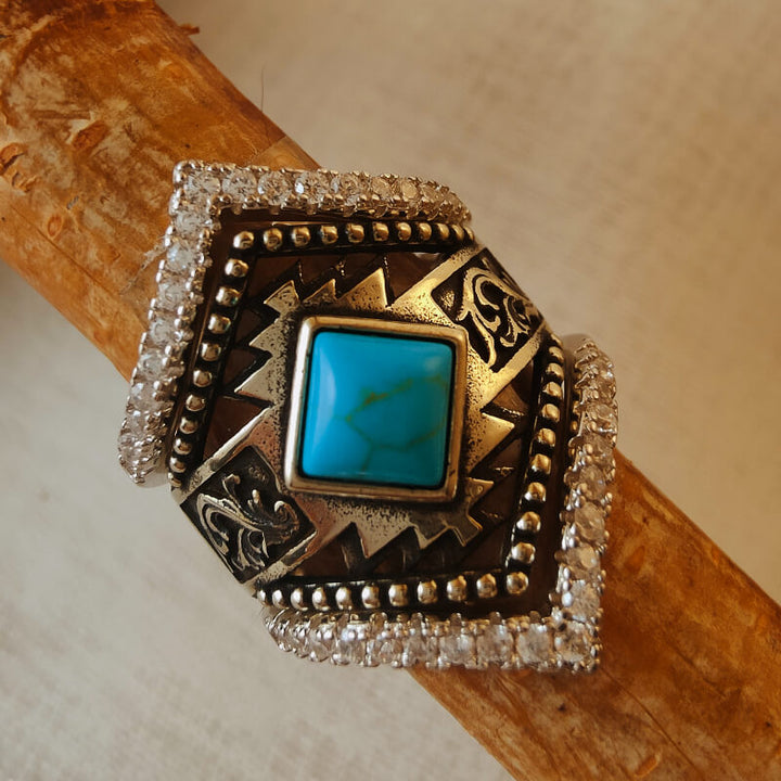 Square cut turquoise ring with silver embellishments and Western motifs