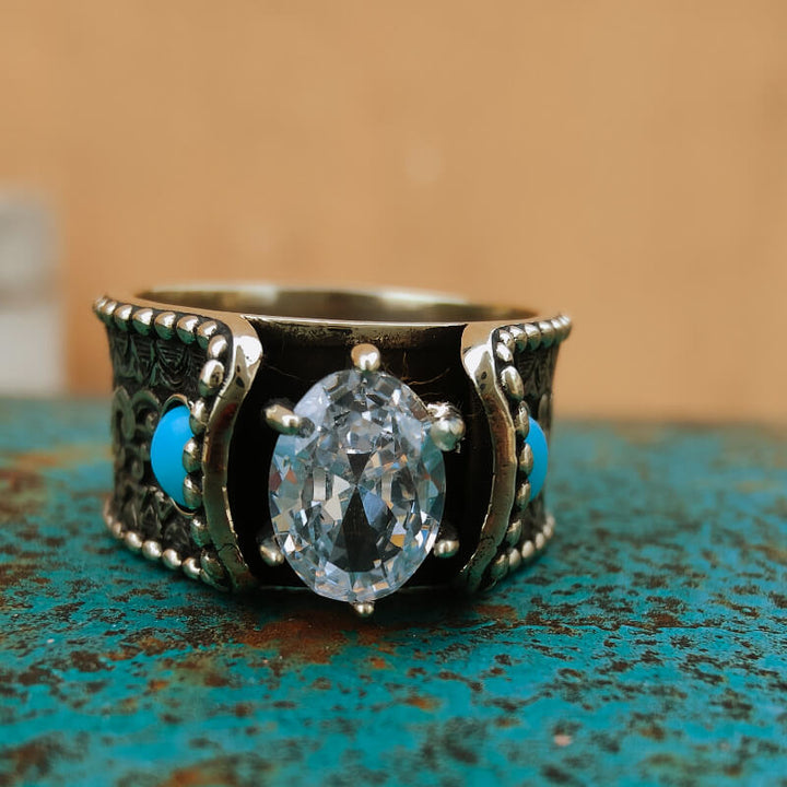Wave engraved flower ring featuring turquoise stones and a central diamond on turquoise surface