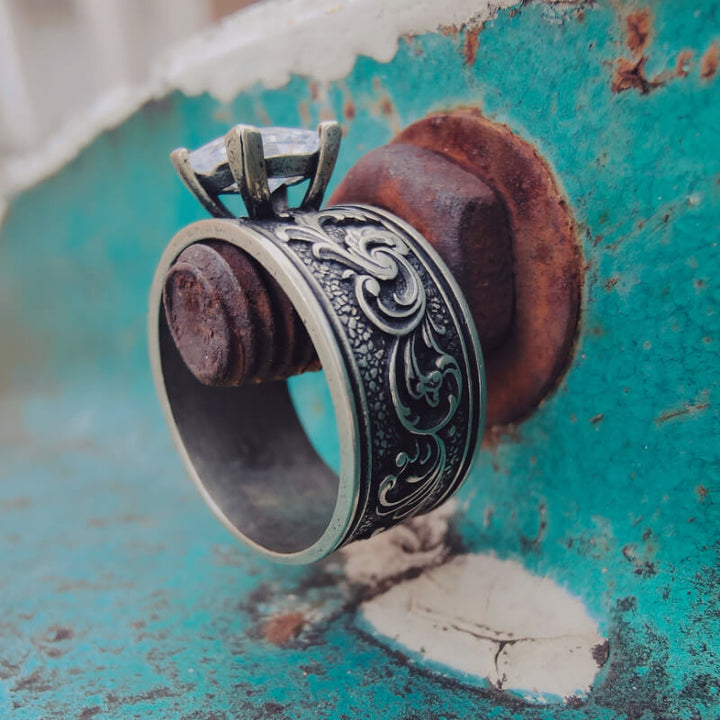 Silver carved band ring with ornate floral design and square diamond