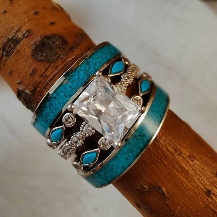 Sterling silver turquoise ring with large diamond and zircon accents on a wooden background.