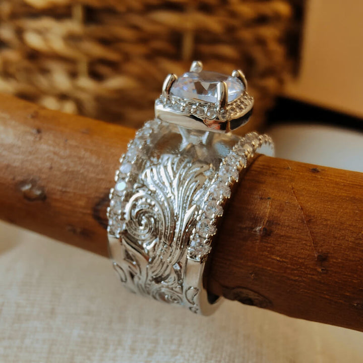 Silver floral engraved ring with large cubic zirconia stone center.