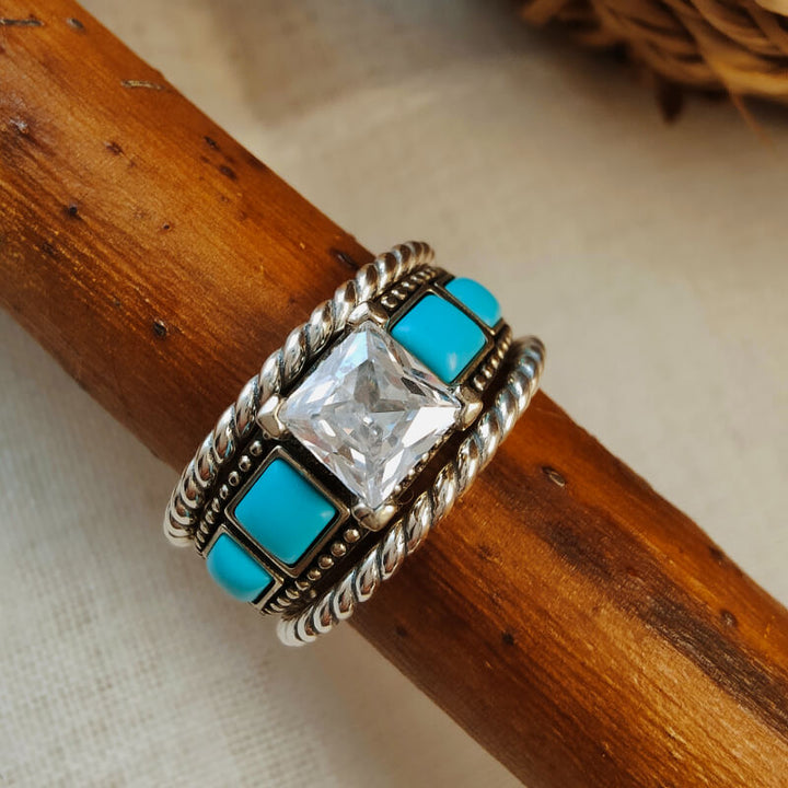 Twisted silver ring with square turquoise stones and diamond centerpiece