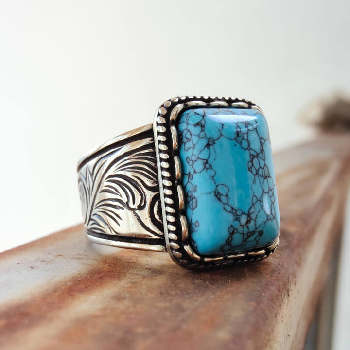 Turquoise rectangle stone set in detailed silver band ring