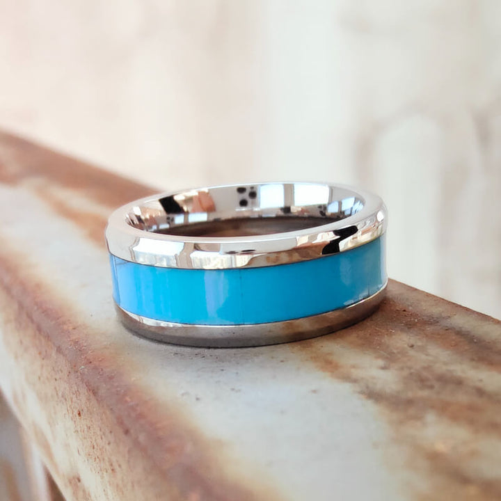 Turquoise inlay band ring with silver frame on rustic background