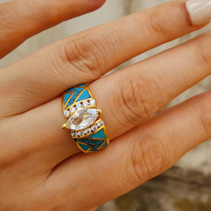Marquise diamond and turquoise inlay gold engagement ring on a hand