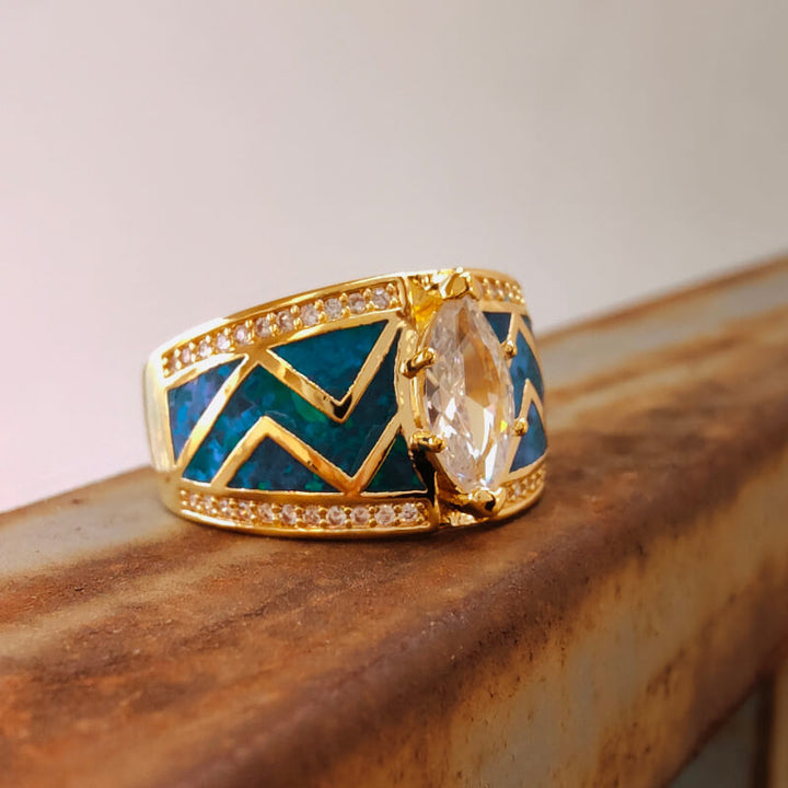Marquise diamond ring with blue opal inlay and zircon on gold zigzag band.