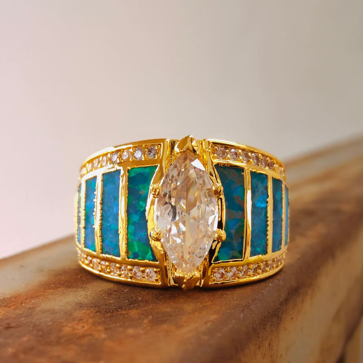 Gold engagement ring with marquise zircon and blue opal inlay.