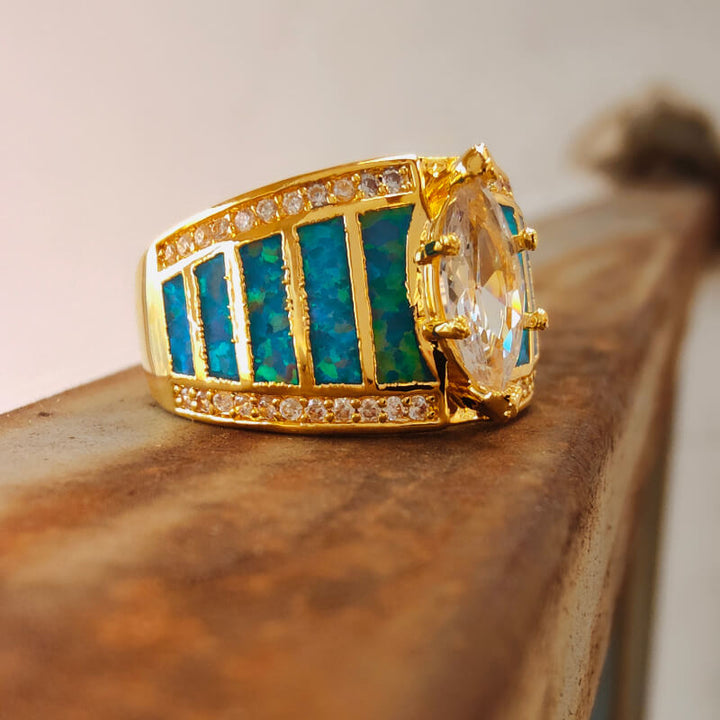 Gold engagement ring with large opal and blue opal inlays adorned with zircon accents.