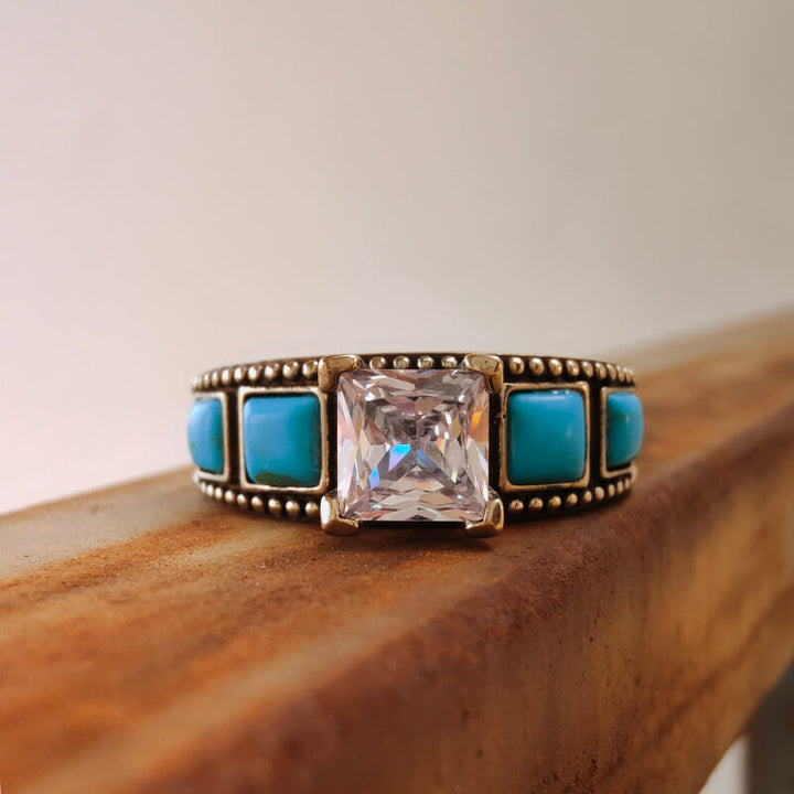 Vintage square turquoise and zircon ring on wooden surface
