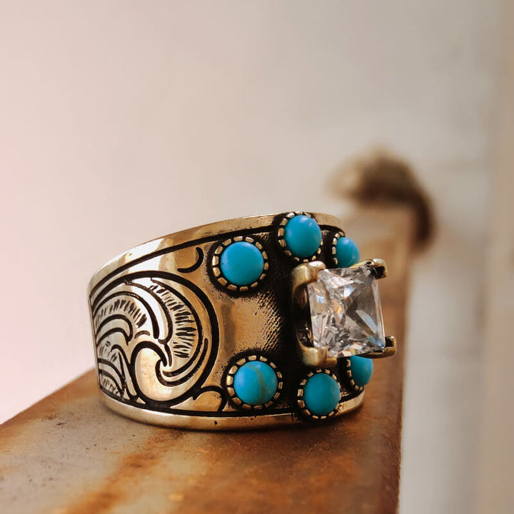 Vintage wide band turquoise ring with diamond center and artistic engravings.