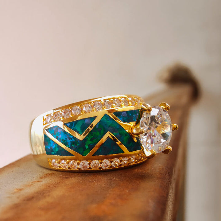 Gold engagement ring with blue opal inlay and sparkling diamond accents