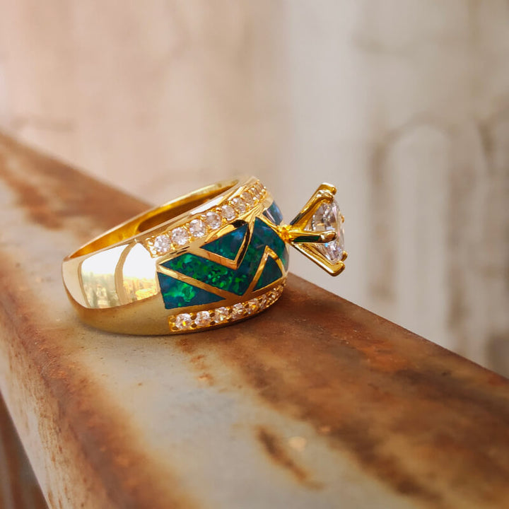 Gold engagement ring featuring blue opal, diamond accents, and geometric design