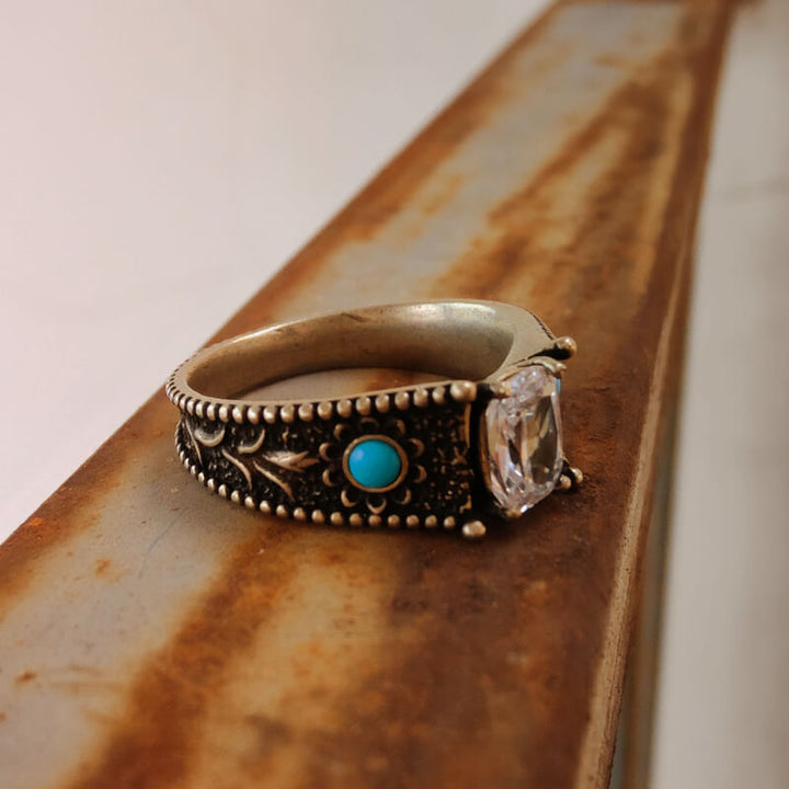 Western turquoise and clear stone engagement ring with floral accents.