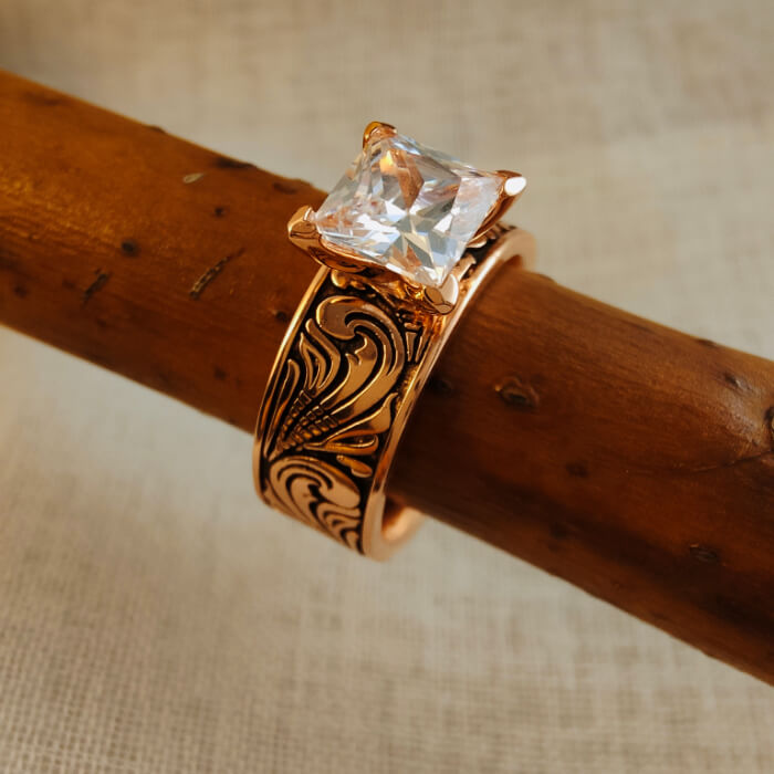 Rose gold wedding ring with intricate floral designs and large square zircon.