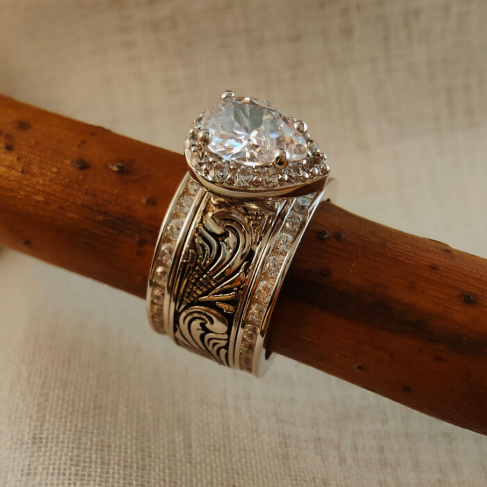 Pear-shaped diamond engagement ring with detailed silver band design
