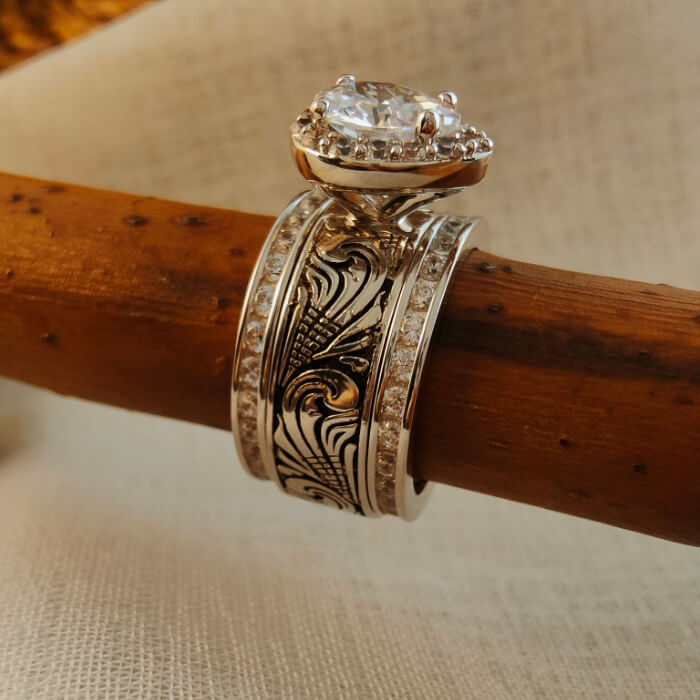 Intricately designed silver engagement ring set with a sparkling pear-shaped diamond
