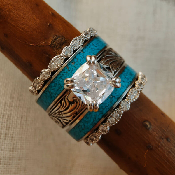 Sterling silver ring set featuring turquoise and diamond accents on a wooden background