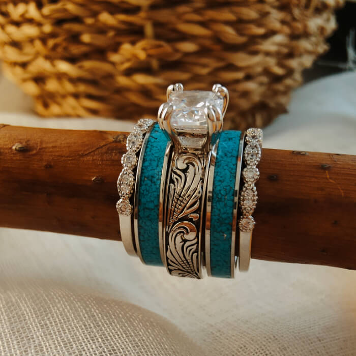 Stylish sterling silver turquoise and diamond ring set displayed on a wooden surface