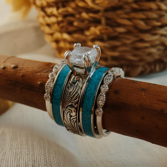 Elegant turquoise and diamond sterling silver ring set on a wooden stick.