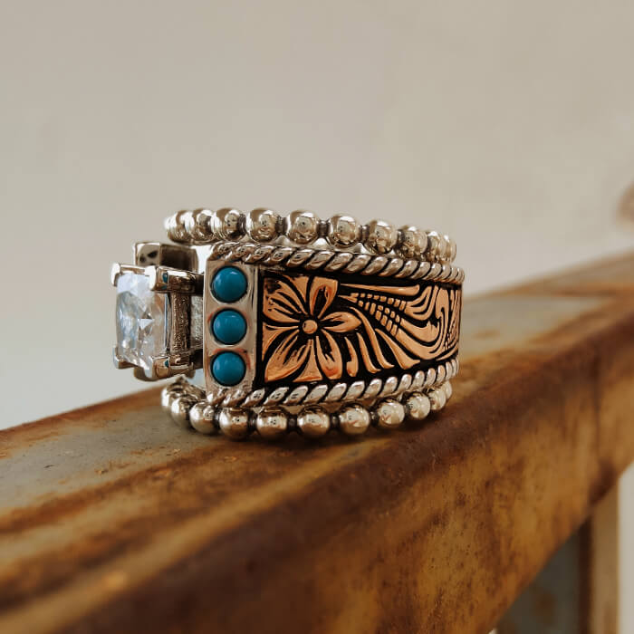 Square diamond engagement ring set with turquoise and ornate floral design.