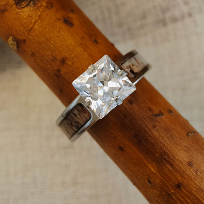 Square diamond ring with antler inlay on wooden surface