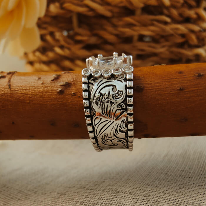 Wide band silver ring with floral engravings and marquise diamond setting