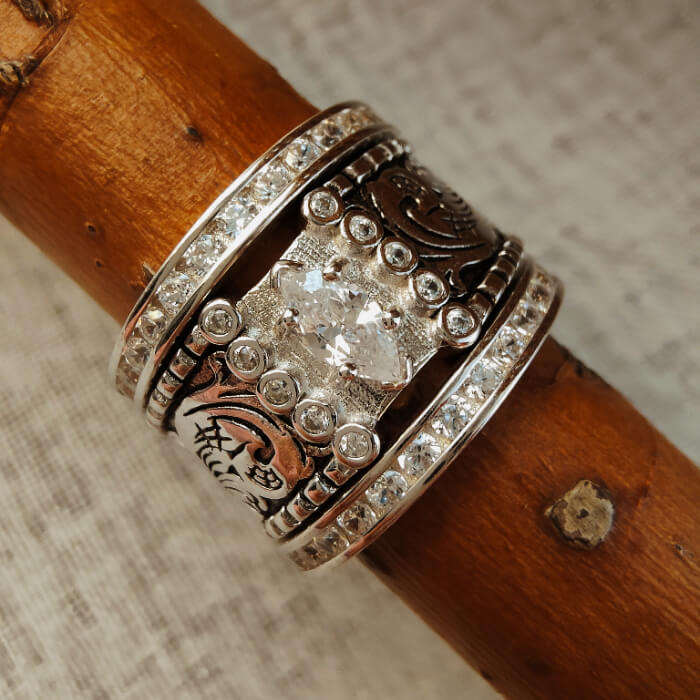 Wide band silver engagement ring with marquise diamond and intricate flower engravings