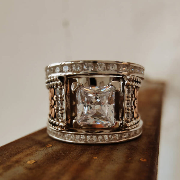 Sterling silver flower engraved ring with a square diamond centerpiece.