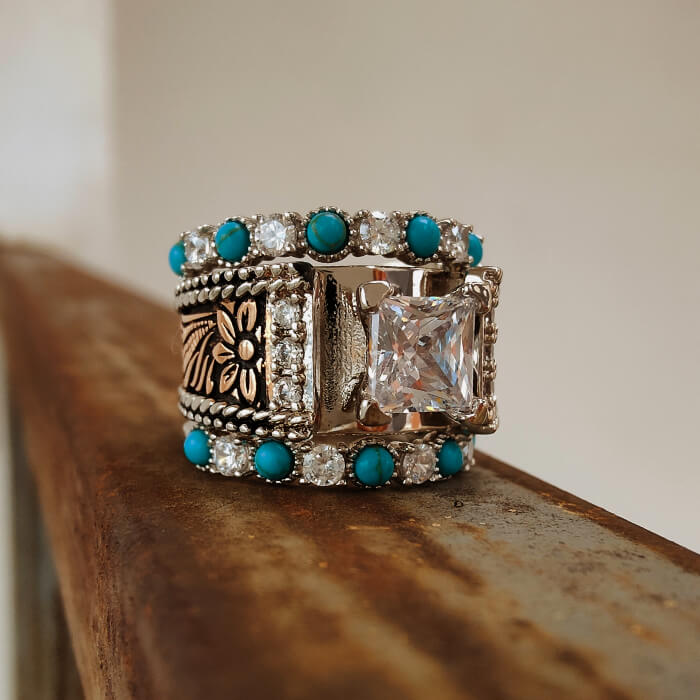 Floral designed silver ring set with turquoise accents and a square moissanite stone.