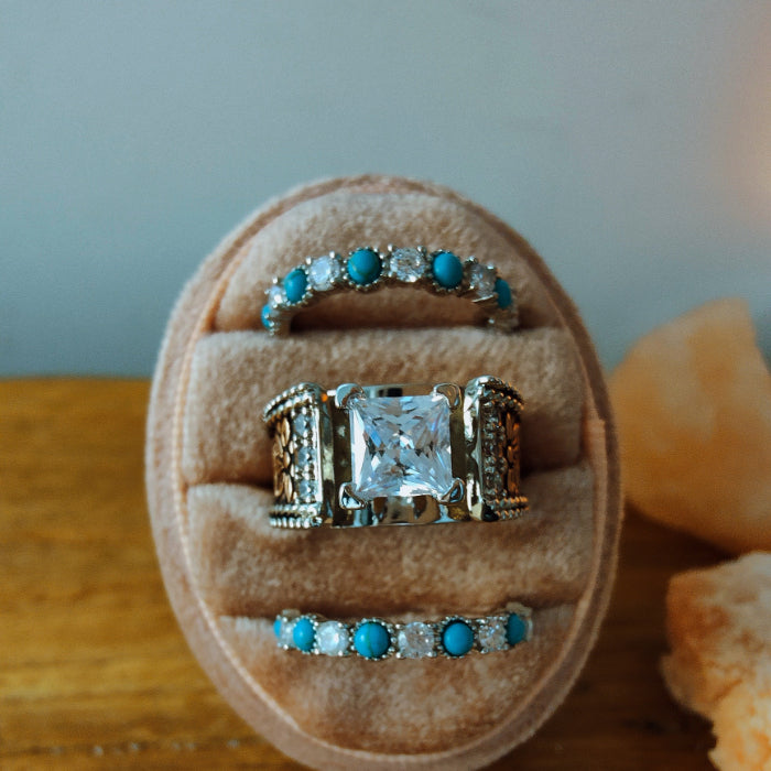 Three-piece engagement ring set featuring turquoise stones and a moissanite center stone