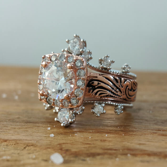 Rose gold engagement ring with large sparkling zircon and floral design accents.