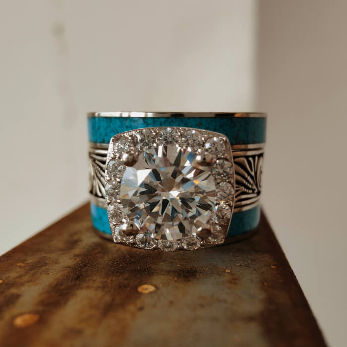 Turquoise and diamond ring showcasing a large center stone and intricate silver details
