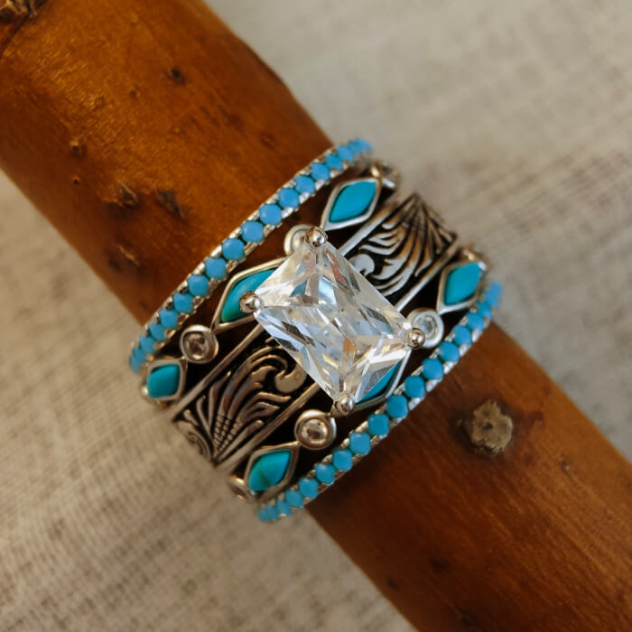 Five-piece turquoise wedding ring set with floral engravings and emerald cut center.