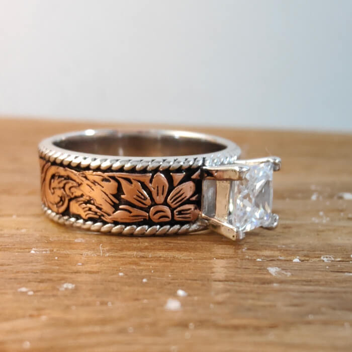 Rose gold and black flower engraved ring with princess cut zircon gemstone.