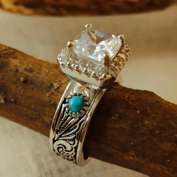 Engagement ring with radiant cut diamond and turquoise on engraved silver-black band