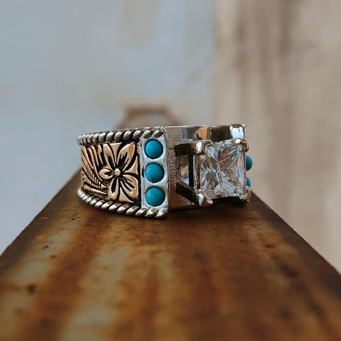 Close-up of Western turquoise diamond ring with floral engravings and blue accents