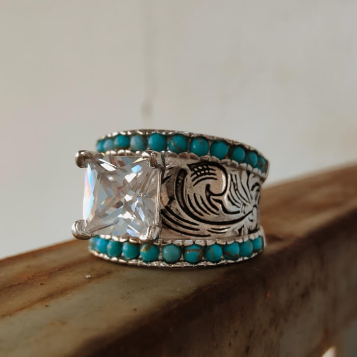 Intricate silver band ring with turquoise stones and large clear center gem