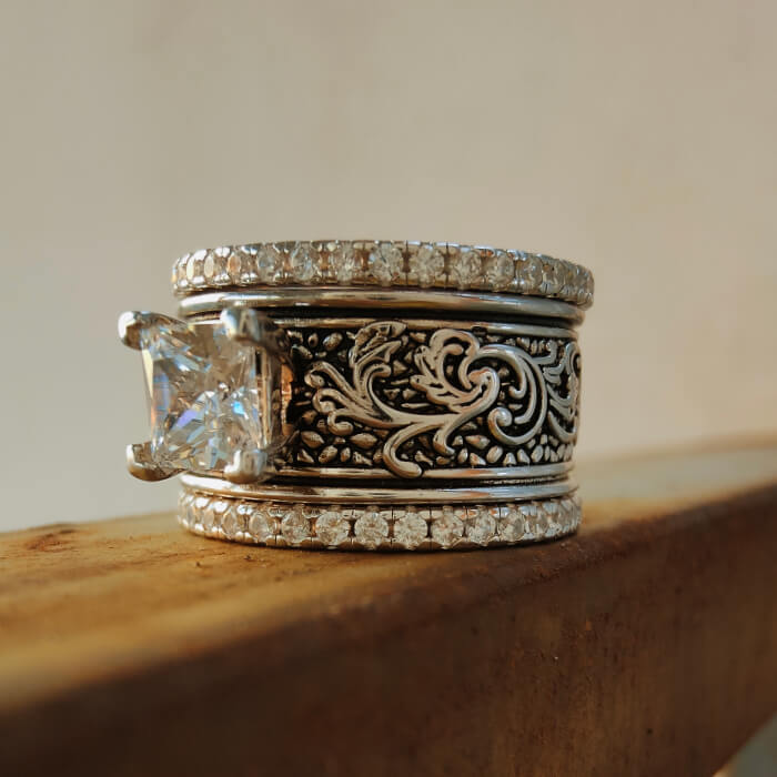 Three-piece Western ring set featuring a large zircon and floral engravings in silver.