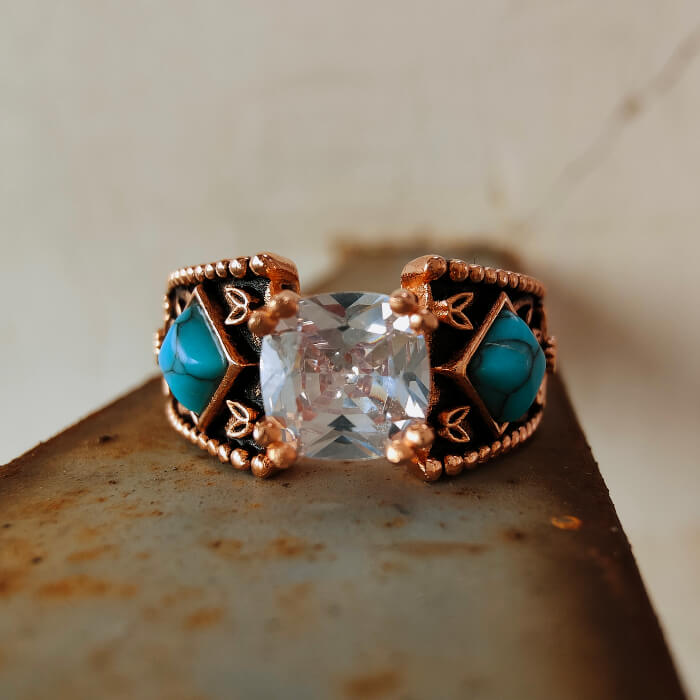 Women's turquoise engagement ring with square zircon and intricate rose gold band.